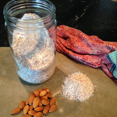 Almond flour in a jar along with some almond nuts on the counter.