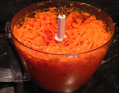 Grated carrots in a food processor bowl.