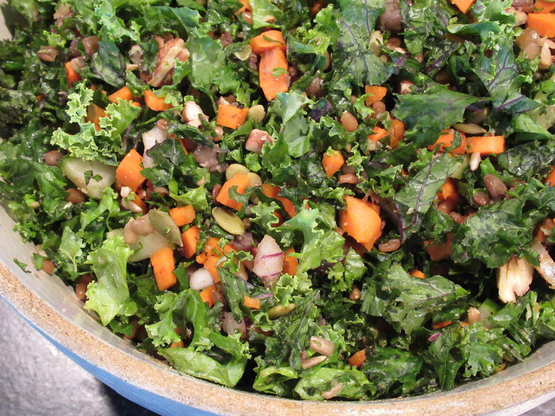 Colorful kale salad in a crockery style bowl.